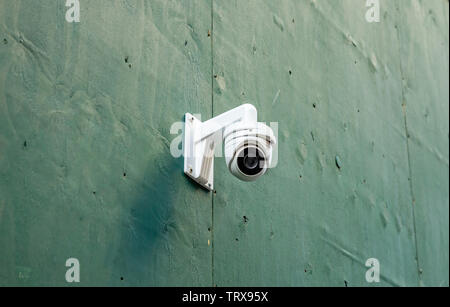 CCTV Security system. Surveillance Camera on a green color wall background, low angle closeup view Stock Photo