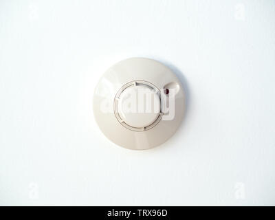 Smoke detector isolated on white ceiling background. Flat lay smoke fire detector. Stock Photo