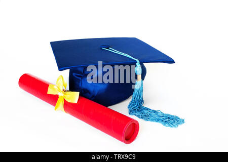 Blue graduation cap or mortarboard with blue tassel and diploma in case with yellow ribbon, isolated on white background. Stock Photo