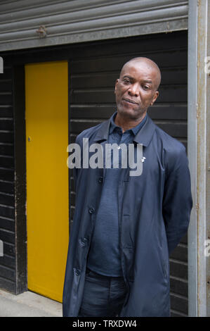 Stafford Scott civil rights campaigner stands outside Reel Rebels radio station at a yellow door as part of the 2019 Stoke Newington Literary Festival Stock Photo