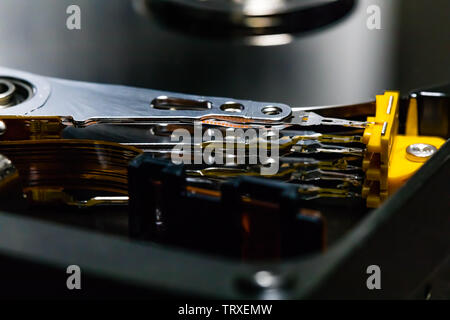 Controller circuit board and hard drive spindle and head actuator in a macro close up of a disassembled hard drive.  The highly polished and reflective Stock Photo