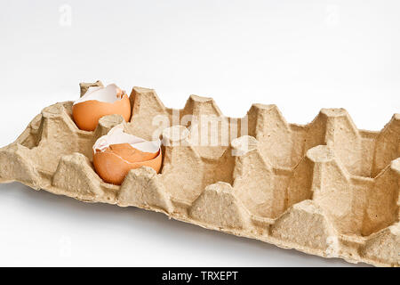Carton packaging for eggs with broken eggshell on a light background. Organic concept Stock Photo