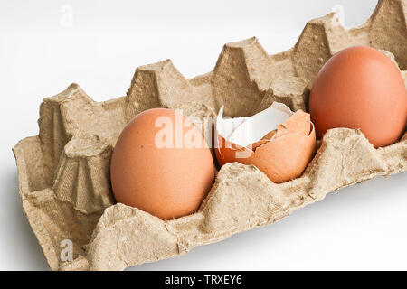 Carton packaging for eggs with broken eggshell and eggs on a light background. Organic concept Stock Photo