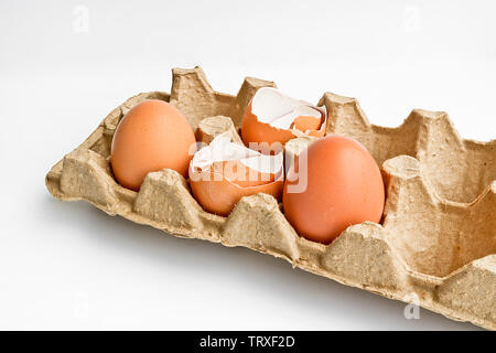 Carton packaging for eggs with broken eggshell and eggs on a light background. Organic concept Stock Photo