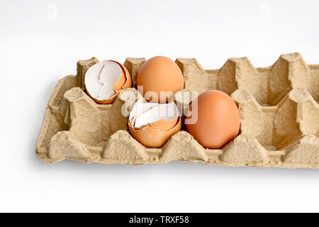 Carton packaging for eggs with broken eggshell and eggs on a light background. Organic concept Stock Photo