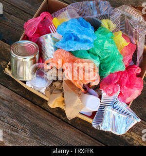 Box with trash on wooden background. Stock Photo