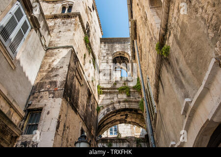 Stone houses with windows and balconies in narrow street of old town of Split, Croatia, inside the palace of Roman emperor Diocletian Stock Photo