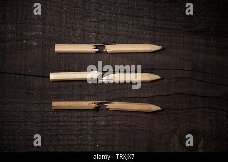 Broken pencils holder on a wooden table. Stock Photo