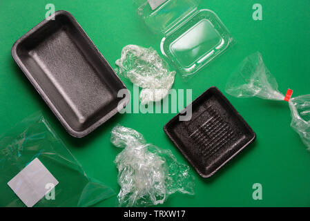 Plastic used disposable food package on green background. Plastic waste, recycle concept. Top view, flat lay Stock Photo