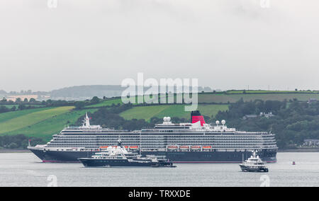 Cork Harbour, Cork, Ireland. 13th June, 2019. Cunard cruise ship Queen Victoria, steams past super yachts Le Grand Bleu and Air on her way to Cobh, Co. Cork. Le Grand Bleu was once owned by Russian billionaire businessman Roman Abramovich and rumoured to have been lost in a bet to another Russion billionaire, Eugene Shvidler. Credit: David Creedon/Alamy Live News Stock Photo