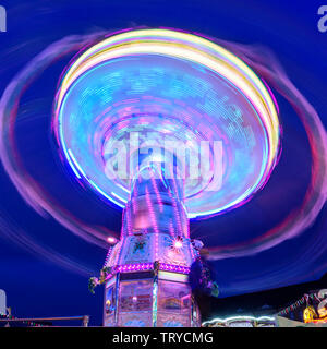 Colorful illuminated fairground attraction - chain carousel Stock Photo