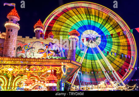 Colorful illuminated fairground attractions on funfair in Augsburg Stock Photo