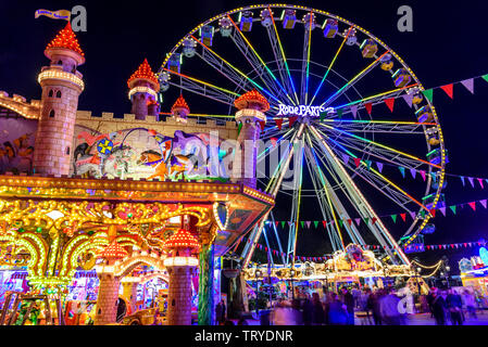 Colorful illuminated fairground attractions on funfair in Augsburg Stock Photo