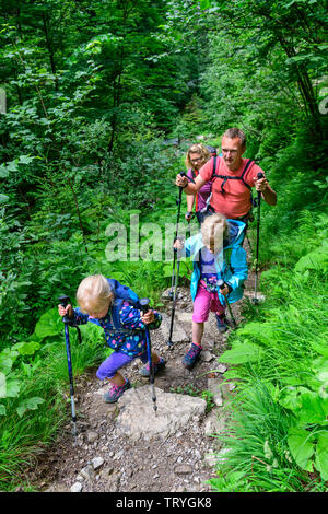 Family hiking on forest trail near Oberstdorf Stock Photo