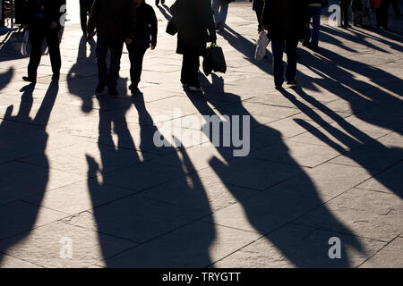 The long shadows of shoppers in a high street in Newcastle upon Tyne, England Stock Photo