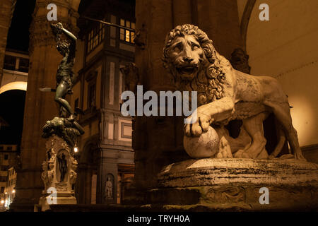 One of the Medici lions at the Loggia dei Lanzi in the Piazza della Signoria in Florence, Italy. To the left is a statue of Perseus. Stock Photo