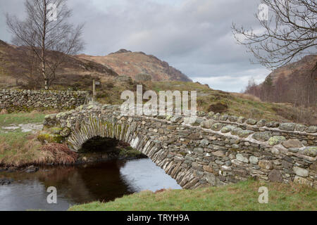 A stone packhorse bridge at Watendlath, which is a hamlet in the Lake District. Cumbria, England Stock Photo