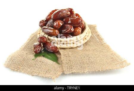 Dried dates on wicker stand sackcloth isolated on white Stock Photo