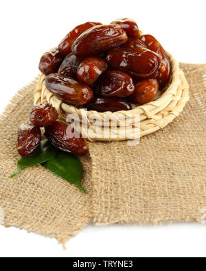 Dried dates on wicker stand sackcloth isolated on white Stock Photo