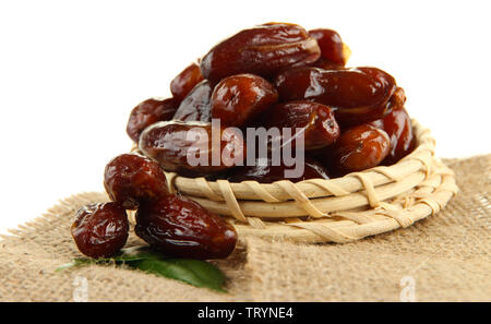 Dried dates on wicker stand sackcloth isolated on white Stock Photo