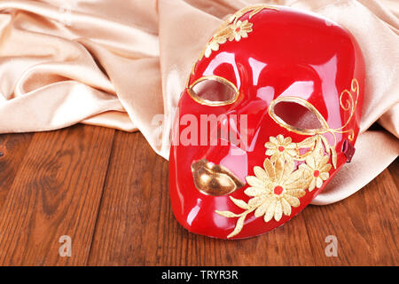 Mask on golden fabric on wooden background Stock Photo