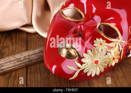 Mask on golden fabric on wooden background Stock Photo