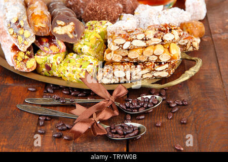 Tasty oriental sweets on tray, on grey wooden background Stock Photo
