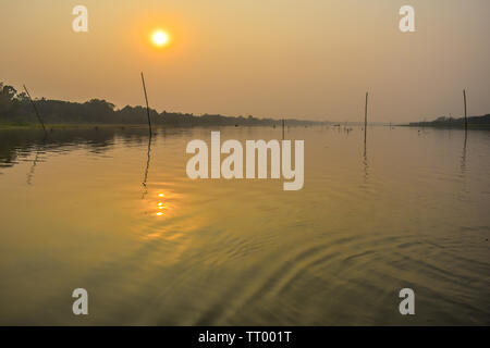 A stunning, natural dramatic, blazing sunset with reflection on over holiest of rivers in India Ganges delta in Sunderbans, West Bengal, India. Stock Photo