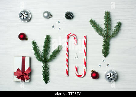 White, green and red christmas composition with candy canes, jingle bells and tiny silver christmas tree Stock Photo