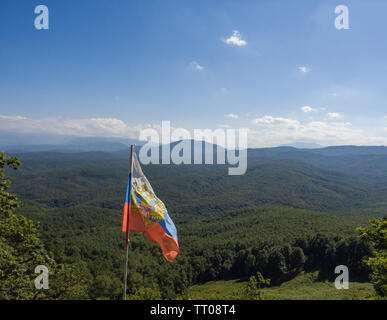 Beautiful Caucasian mountain panorama with the Russian flag. Stock Photo