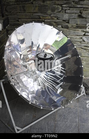 A solar cooker is a device which uses the energy of direct sunlight to heat, cook or pasteurize drink and other food materials. Many solar cookers cur Stock Photo