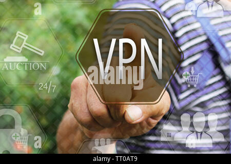 Elderly businessman, the farmer chooses  a VPN on the touch screen. Virtual private network web tag.Сoncept internet technology. Stock Photo