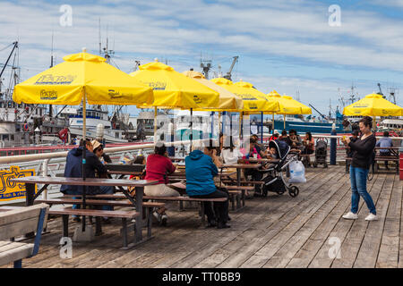 Tourists enjoying Fish and Chips on a wooden deck along the Steveston waterfront in British Columbia Canada Stock Photo