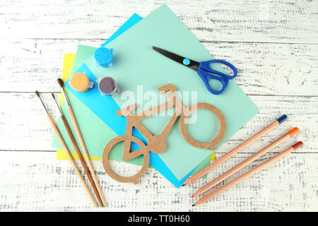 Decorative bicycle with needlework composition on wooden background Stock Photo