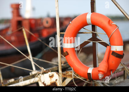Lifebuoy and a lantern on the board of the port tugboat Stock Photo