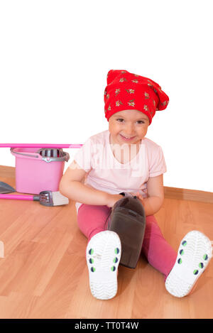 Little girl with toy cleaning equipment sitting on the floor isolated Stock Photo