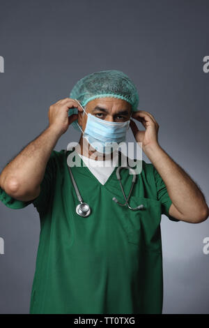 Male surgeon putting on surgical mask Stock Photo
