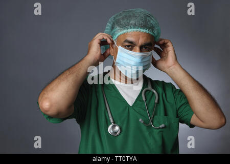Male surgeon putting on surgical mask Stock Photo