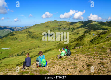 Family enjoying impressive view on mountain top in the morning Stock Photo