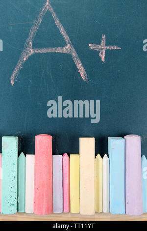 Education rating and colorful chalks on school desk Stock Photo