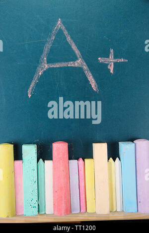 Education rating and colorful chalks on school desk Stock Photo