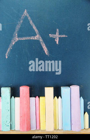 Education rating and colorful chalks on school desk Stock Photo