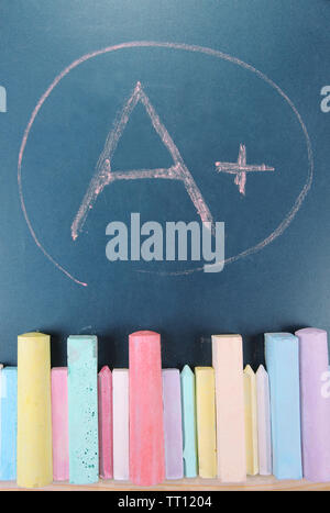 Education rating and colorful chalks on school desk Stock Photo