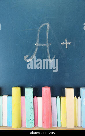 Education rating and colorful chalks on school desk Stock Photo