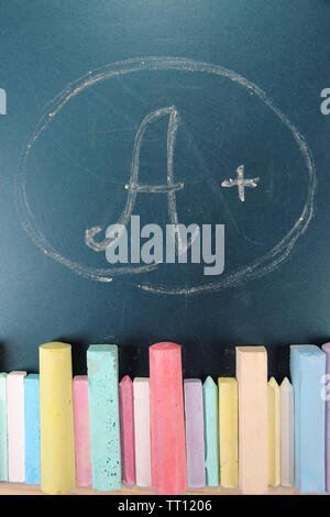 Education rating and colorful chalks on school desk Stock Photo