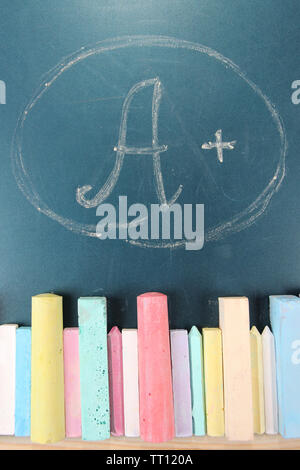 Education rating and colorful chalks on school desk Stock Photo