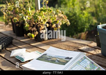 A book on a table in a garden, open to a page about farm design. Stock Photo