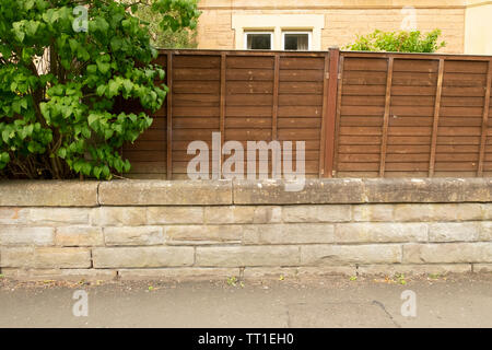 Stone wall and wooden fence, in the Victorian suburban of Morningside, Edinburgh, Scotland, UK Stock Photo