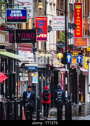 Brick Lane shops and restaurants - Brick Lane is a vibrant restaurant, nightclub and shopping street in the Shoreditch area of East London. Stock Photo