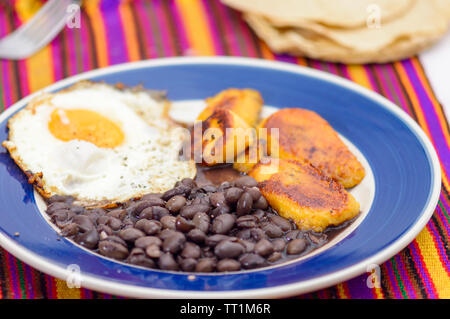 Mexican tropical breakfast, made with plantains, eggs and black beans with tortillas, copy space Stock Photo